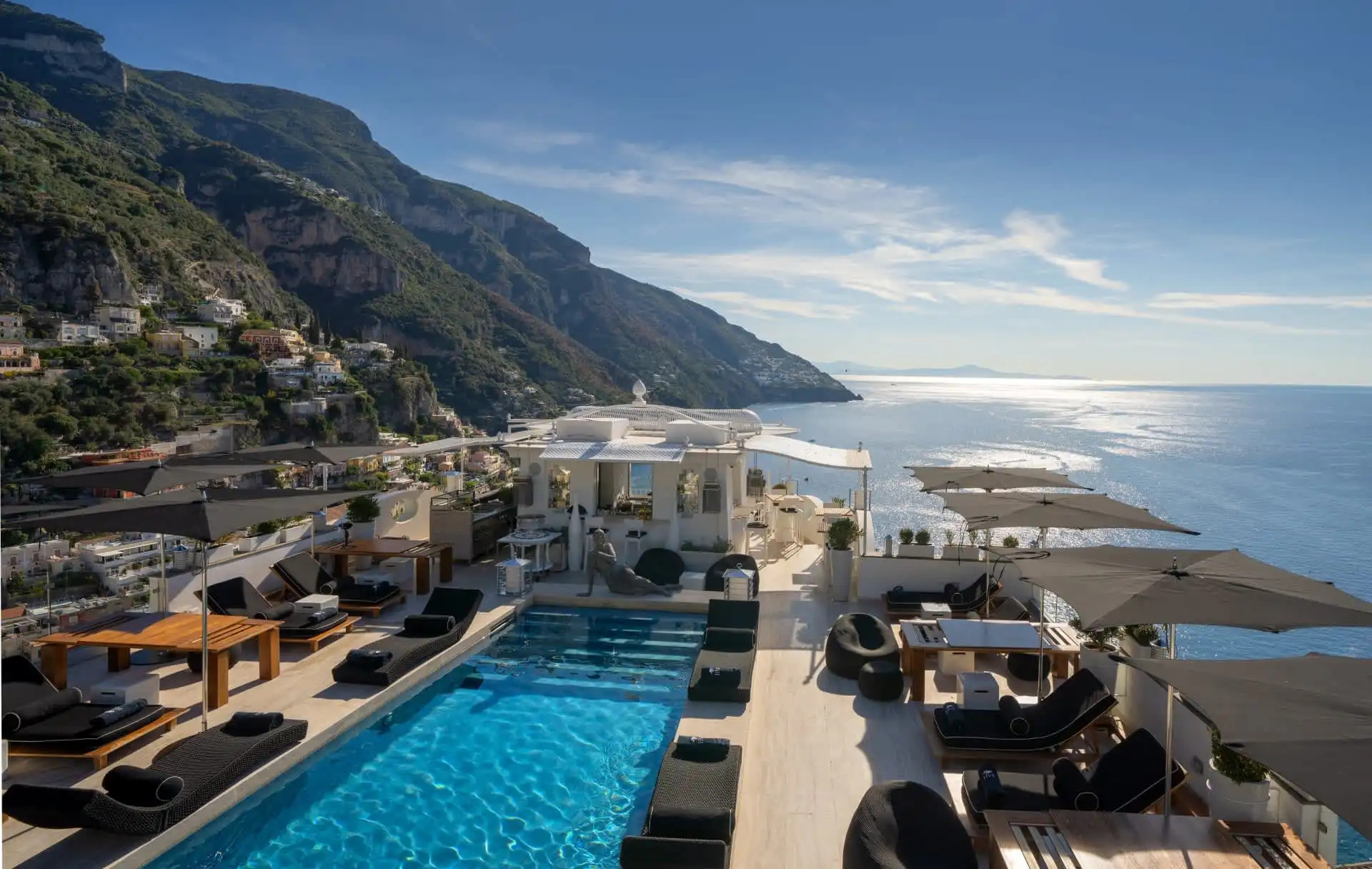 Iconic colorful buildings cascading down the cliffs of Positano with the Mediterranean Sea and boats in the harbor